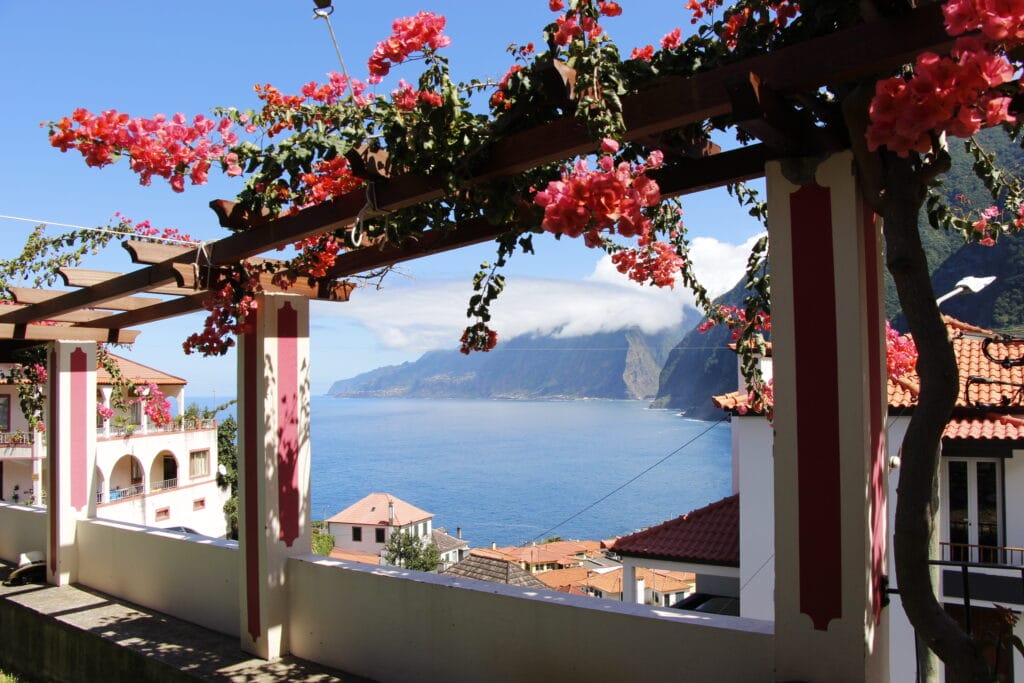 Blick aufs Meer umrahmt von einer mit Blumen bewachsenen Pergola